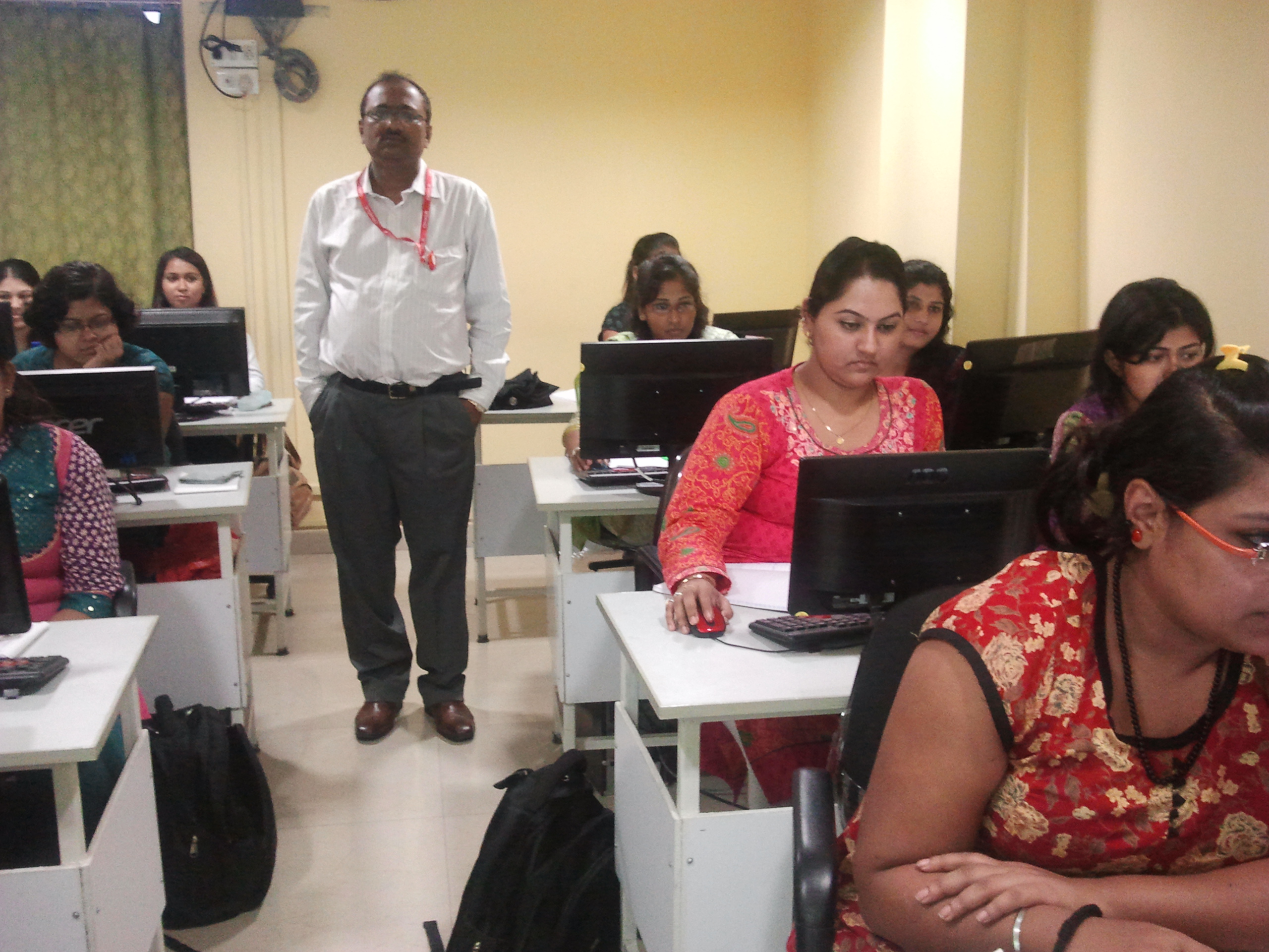 Trainer monitoring students in computer class